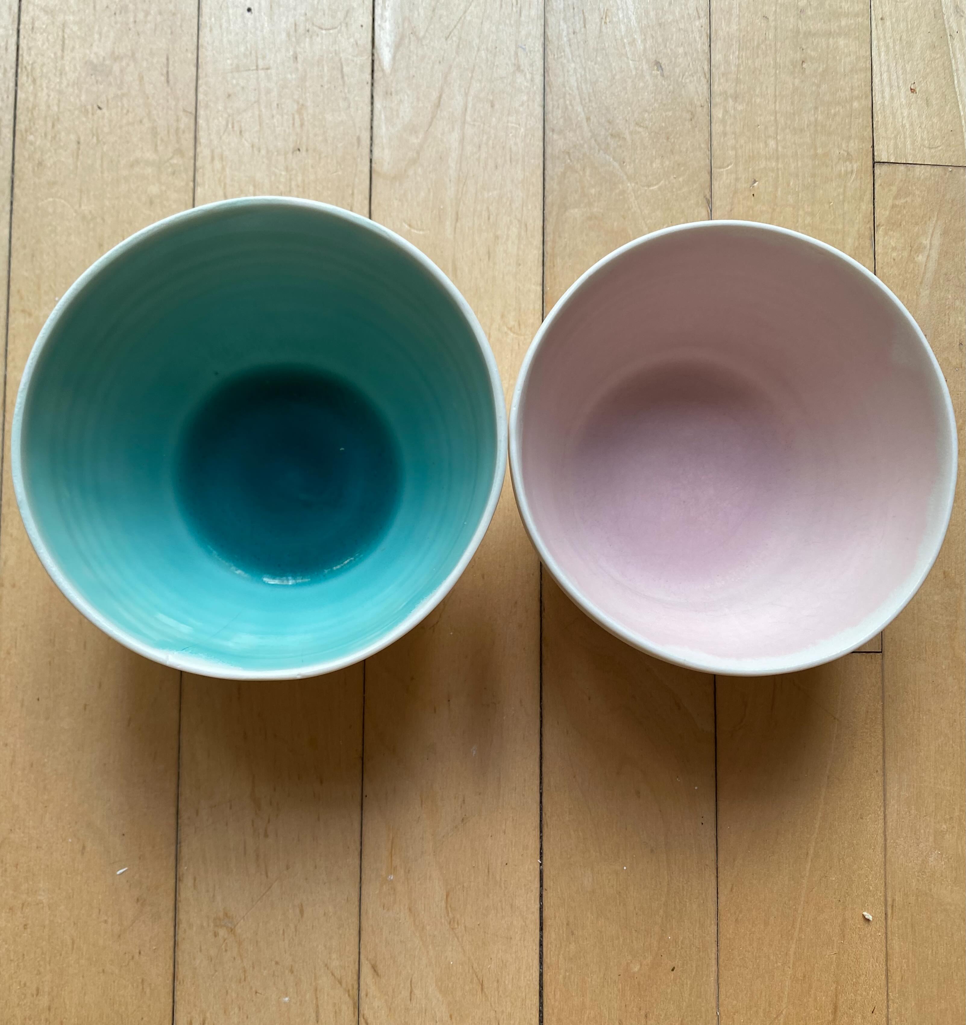 I’ve been making this tableware range for 20 years, porcelain with a satin matt glaze on the outside and coloured glazes on the inside. I use the same base glaze, a runny, glossy transparent, to which I add various colouring oxides.

We use these bowls every day and it’s interesting to see how they fare in the dishwasher. The turquoise glaze containing 1% copper oxide is still glossy after hundreds of washes in the dishwasher. However, the pink glaze containing 2% rutile and 4% tin oxide has turned matt and has some faint metal marking from cutlery.

I had a look at the molecular formula of the glaze, it’s chemically stable with a flux ratio 0.3:0.7 alkali metals to alkaline earths. Both copper oxide and tin oxide act like alkali metal fluxes. However, the larger amount of tin oxide (4%, 0.1 in the UMF) is bringing the total alkali metal flux close to the 0.4:0.6 limit for chemically stable glazes. 

Tin is essential for the pink colour in chrome-tin pink glazes. In this glaze, the chromium is one of the impurities in the rutile. While rutile stabilises the glaze, this pink glaze is slightly less chemically stable owing to the addition of tin oxide.
