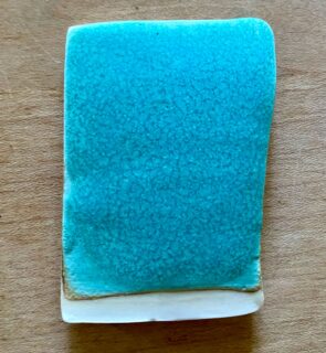 I’ve had this glaze test submerged one third in vinegar overnight and it looks fine. On closer inspection, it’s possible to see tiny pinholes in the glaze near the top of the test tile which have become slighty larger after soaking in vinegar for 18 hours. I’m not too worried about this as I wouldn’t normally leave acidic liquids in a bowl for more than an hour.

This glaze does not have the ideal flux ratio of 0.3:0.7 alkali metal to alkaline earths; it’s closer to 0:5:0.5 as it contains lithium carbonate. By removing the lithium and adding more strontium or calcium I can improve the chemical stability of the glaze.